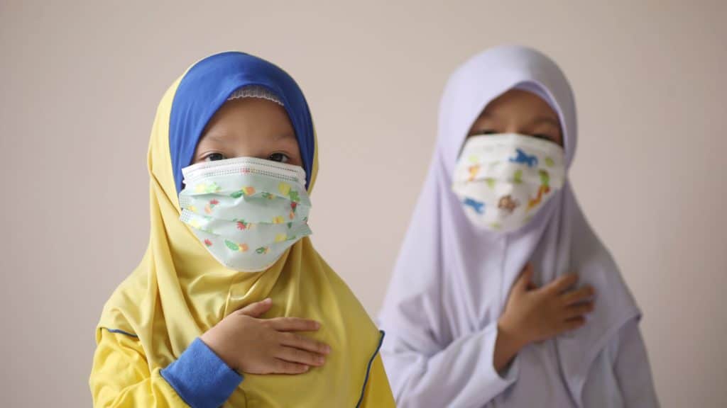 two small girls with hijabs and face masks