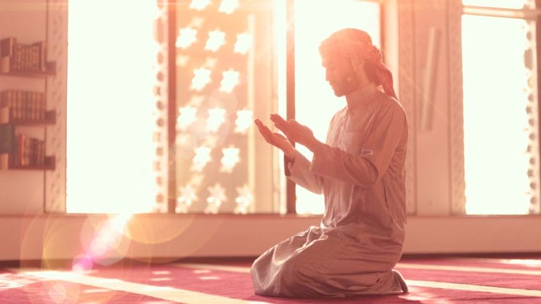 man praying by raising his hands