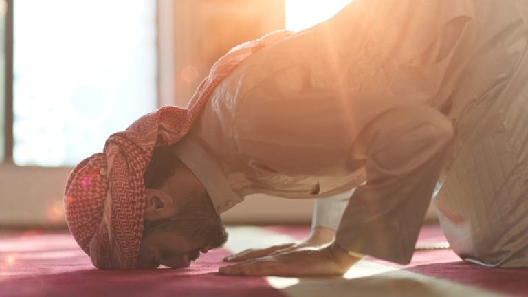 man prostrating in prayer
