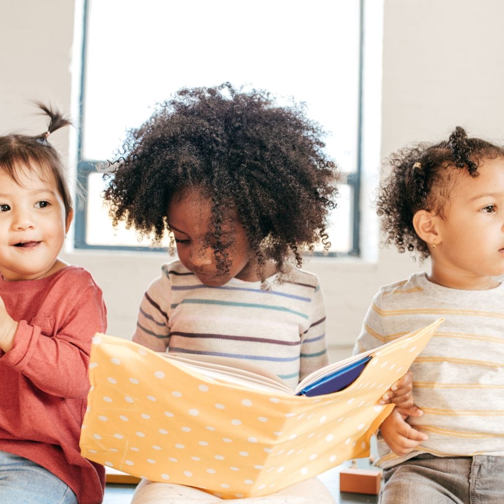 problems with gentle parenting depicted by toddlers group with one of them holding a book